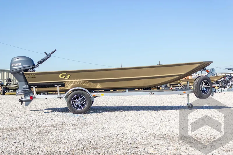 Slide: The Image of 2026 G3 Gator Tough 1652 VBW boat on trailer with Yamaha motor, parked outdoors. - 13