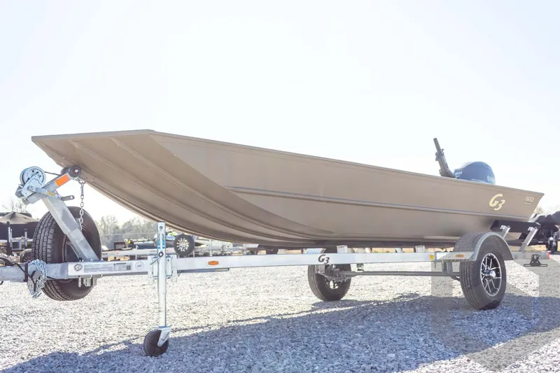 Slide: The Image of 2026 G3 Gator Tough 1652 VBW boat on trailer, parked on gravel. - 9
