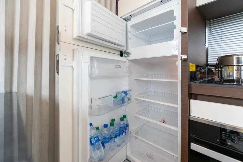 Slide: The Image of Open Prestige 520 refrigerator, stocked with water bottles, in a modern kitchen setting. - 20