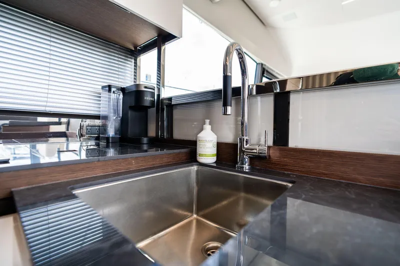Slide: The Image of Modern kitchen sink area in 2022 Prestige 520 yacht, featuring sleek design and appliances. - 22