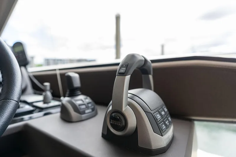 Slide: The Image of Control panel of a 2022 Prestige 520 yacht, featuring modern throttle and joystick. - 34