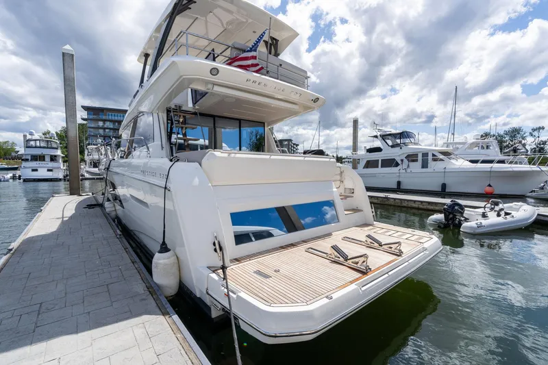 Slide: The Image of Luxury 2022 Prestige 520 yacht docked at marina under cloudy sky. - 4