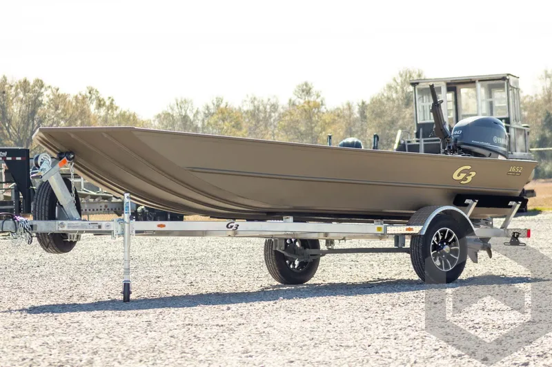 The Image of 2026 G3 Gator Tough 1652 VBW boat on trailer, outdoors, with Yamaha motor. - 1