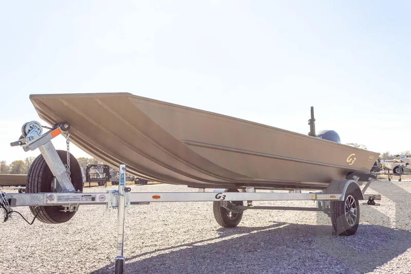 Slide: The Image of 2026 G3 Gator Tough 1652 VBW boat on trailer, parked on gravel. - 10