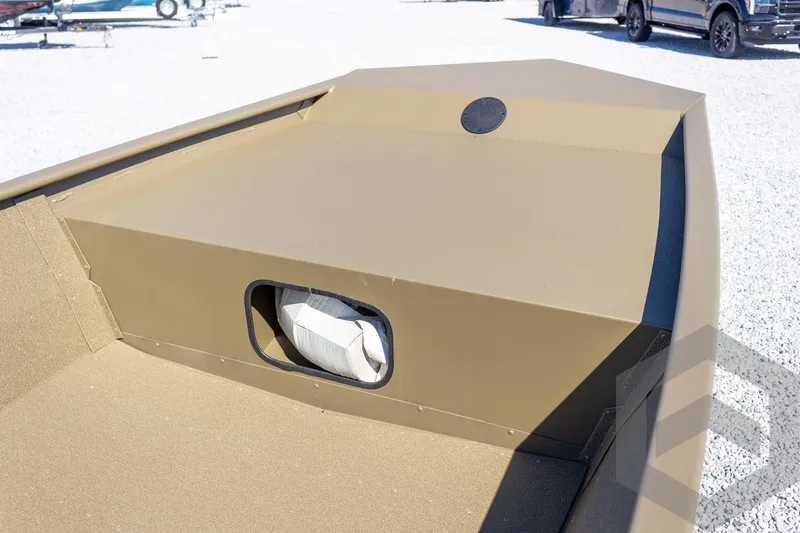 Slide: The Image of 2026 G3 Gator Tough 1652 VBW boat, tan interior, storage compartment, outdoor setting. - 19