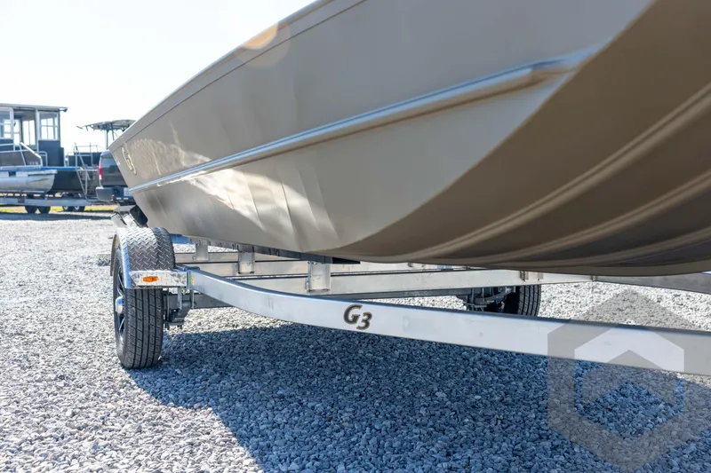 Slide: The Image of 2026 G3 Gator Tough 1860 VBW boat on trailer, parked on gravel. - 11