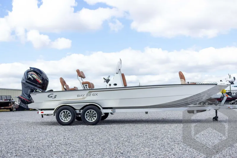 Slide: The Image of 2026 G3 Bay 22 GX boat on trailer, parked on gravel under cloudy sky. - 16