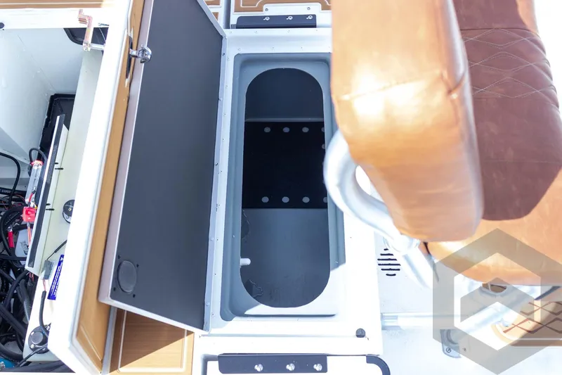 Slide: The Image of Open storage compartment in 2026 G3 Bay 22 GX boat with brown seat. - 53