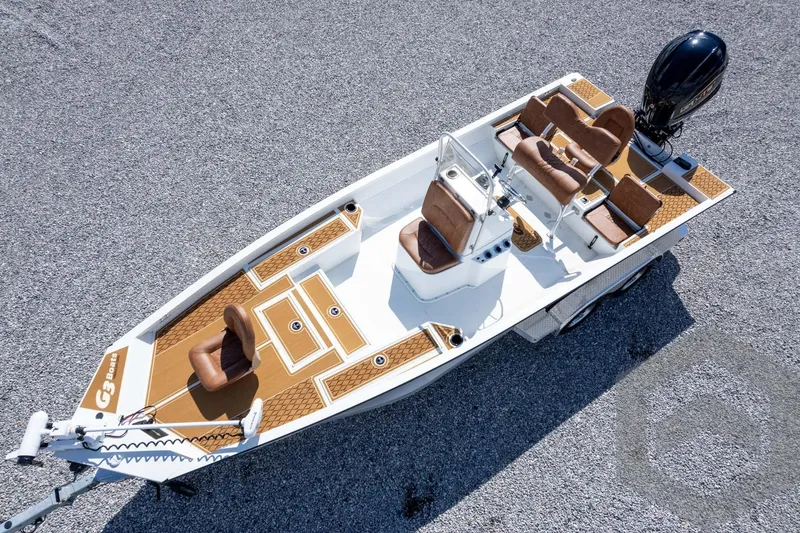 Slide: The Image of 2026 G3 Bay 22 GX boat with brown seating and modern design on gravel surface. - 60