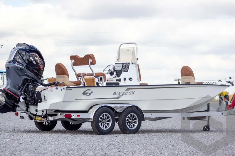 Slide: The Image of 2026 G3 Bay 22 GX boat on trailer with Yamaha outboard motor, parked on gravel. - 7