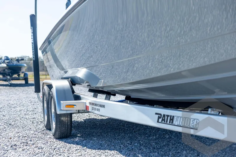 Slide: The Image of 2026 Pathfinder 2500 Hybrid boat on trailer, parked on gravel surface. - 13