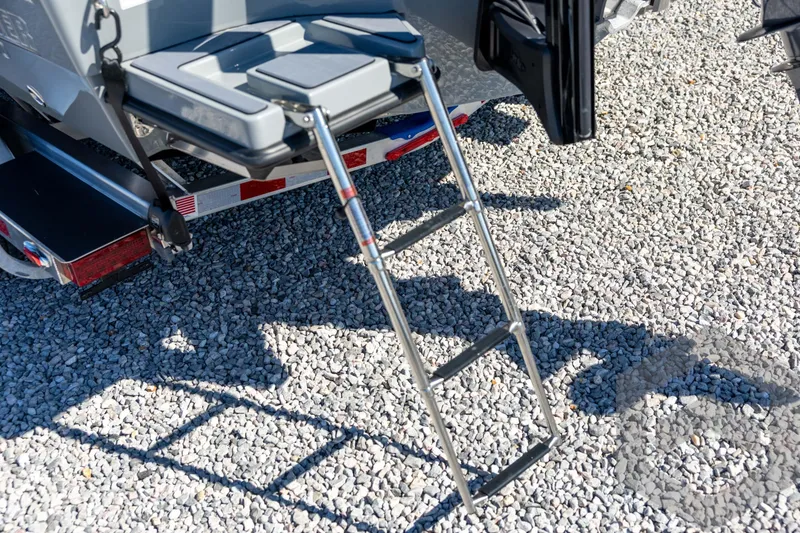 Slide: The Image of Stainless steel ladder on 2026 Pathfinder 2500 Hybrid boat, resting on gravel. - 30