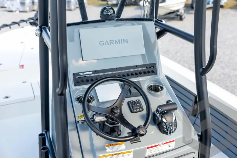 Slide: The Image of 2026 Pathfinder 2500 Hybrid boat console with Garmin display and steering wheel. - 68