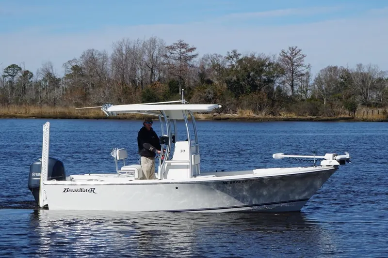 Slide: The Image of 2015 KenCraft BreakWater 20 boat on a calm river with a person onboard. - 8
