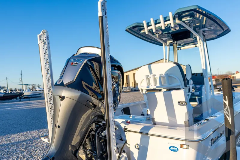 Slide: The Image of 2026 Tidewater 2110 Bay Max boat with powerful outboard motor, docked under clear blue sky. - 25
