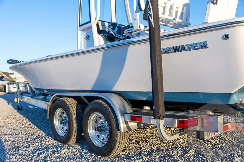 Slide: The Image of 2026 Tidewater 2110 Bay Max boat on trailer, parked on gravel under clear blue sky. - 27