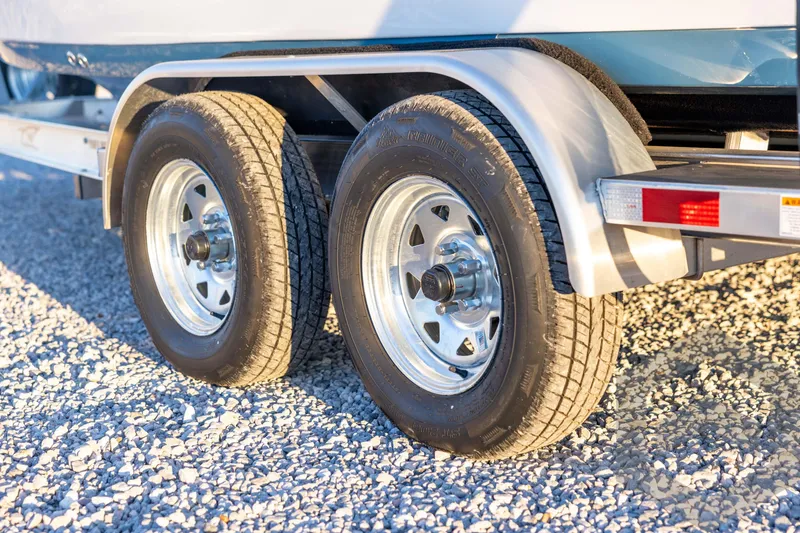 Slide: The Image of 2026 Tidewater 2110 Bay Max trailer wheels on gravel surface. - 28