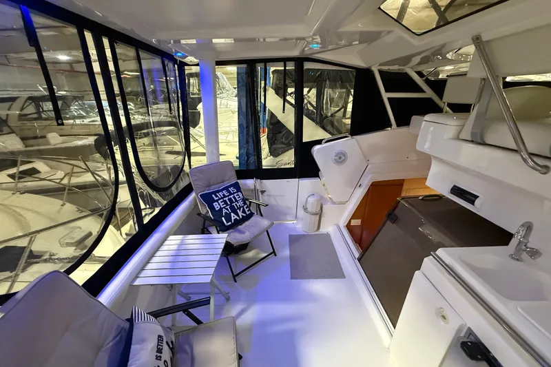 Slide: The Image of 1998 Silverton 352 Motor Yacht interior with seating, table, and lake-themed decor. - 10