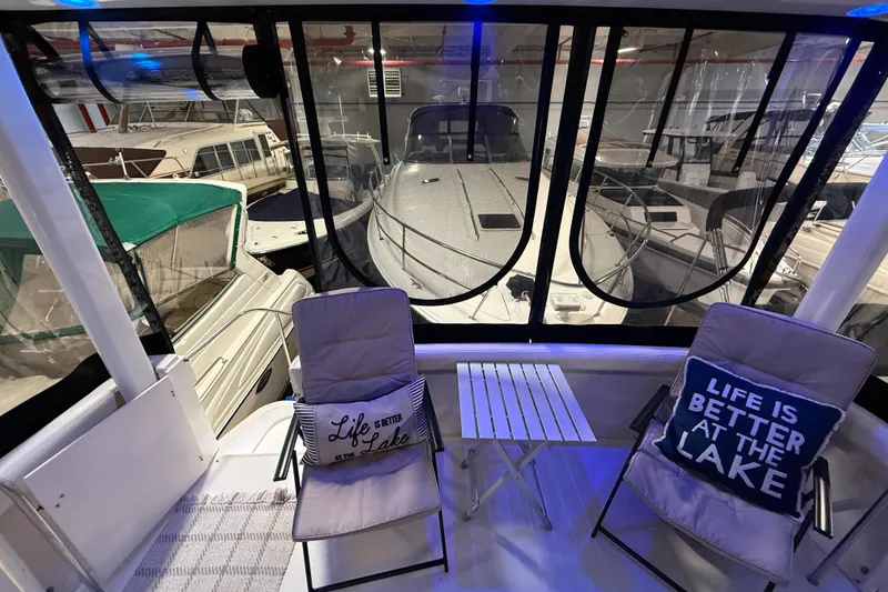 Slide: The Image of 1998 Silverton 352 Motor Yacht interior with chairs, table, and lake-themed pillows. - 11