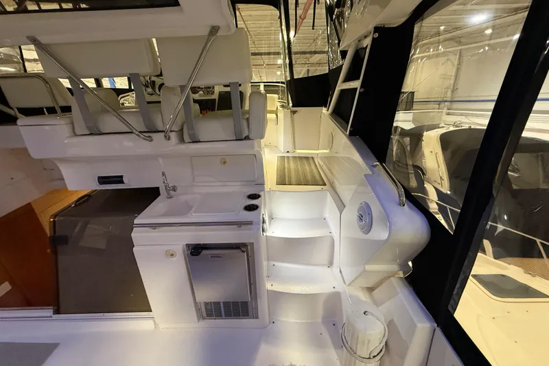 Slide: The Image of 1998 Silverton 352 Motor Yacht interior with seating, kitchenette, and steps. - 14