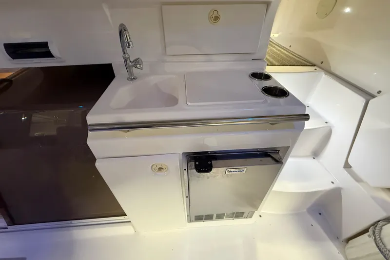 Slide: The Image of 1998 Silverton 352 Motor Yacht kitchenette with sink, faucet, and mini fridge. - 15