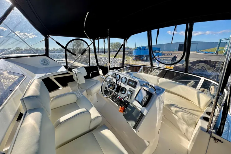 Slide: The Image of 1998 Silverton 352 Motor Yacht cockpit with steering wheel, gauges, and seating under canopy. - 17