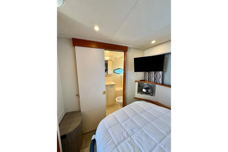 Slide: The Image of 1998 Silverton 352 Motor Yacht interior with bedroom, TV, and bathroom view. - 38