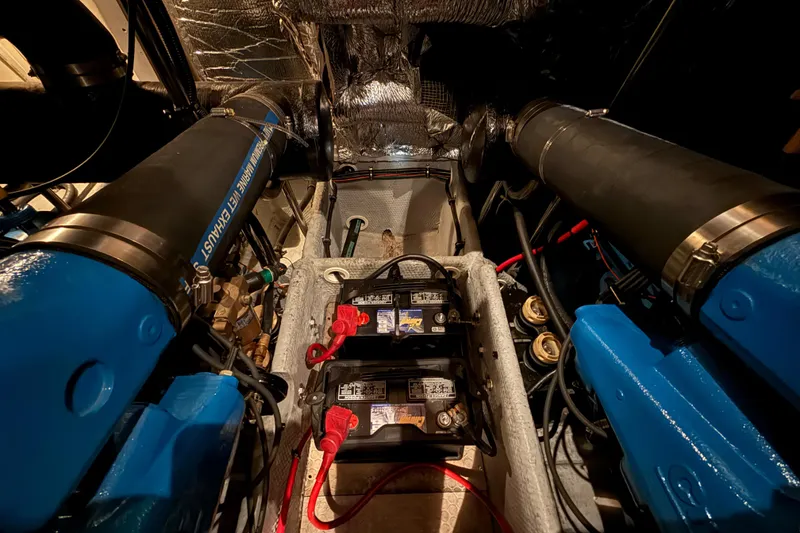 Slide: The Image of Engine room of a 1998 Silverton 352 Motor Yacht with visible batteries and exhaust system. - 49