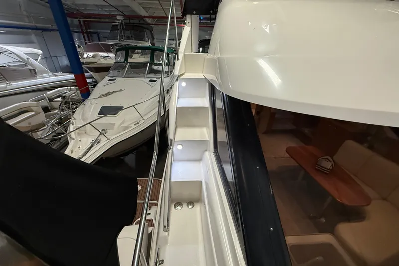 Slide: The Image of 1998 Silverton 352 Motor Yacht interior with illuminated stairs in a marina setting. - 6