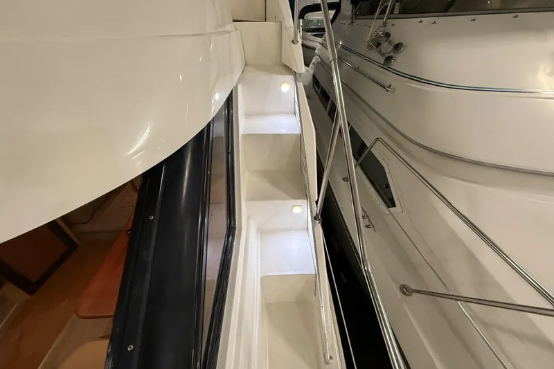 Slide: The Image of 1998 Silverton 352 Motor Yacht with illuminated stairs and sleek white exterior. - 7
