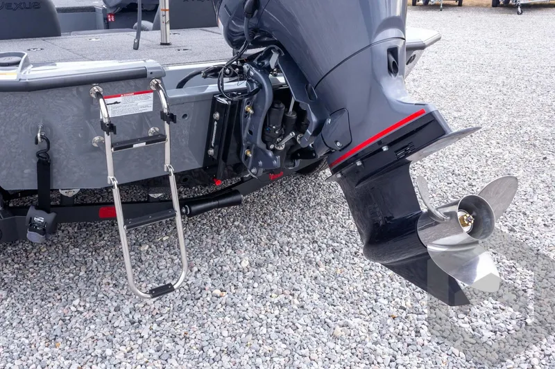 Slide: The Image of 2026 Vexus AVX 1980 boat with outboard motor and ladder on gravel surface. - 32