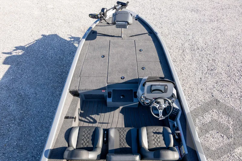 Slide: The Image of 2026 Vexus AVX 1980 boat interior with steering console and seating, on gravel surface. - 77