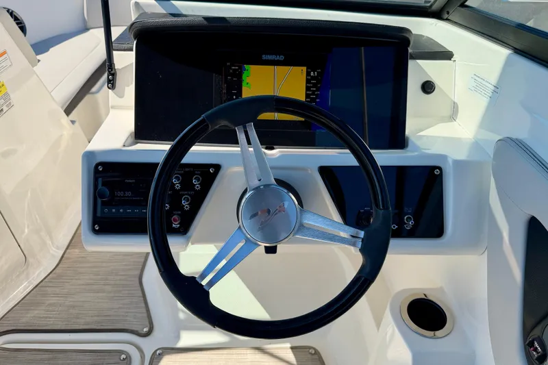 Slide: The Image of 2023 Sea Ray SPX 210 Outboard dashboard with steering wheel and navigation display. - 18