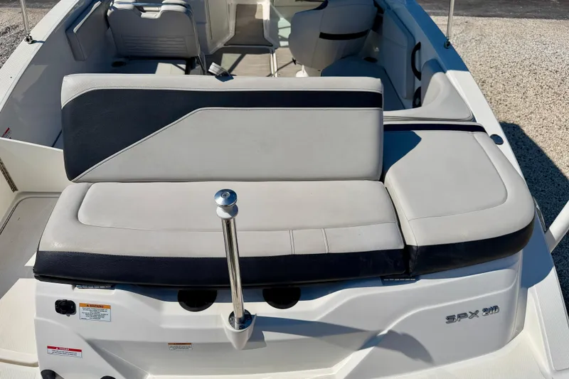 Slide: The Image of 2023 Sea Ray SPX 210 Outboard boat interior with cushioned seating and sleek design. - 23
