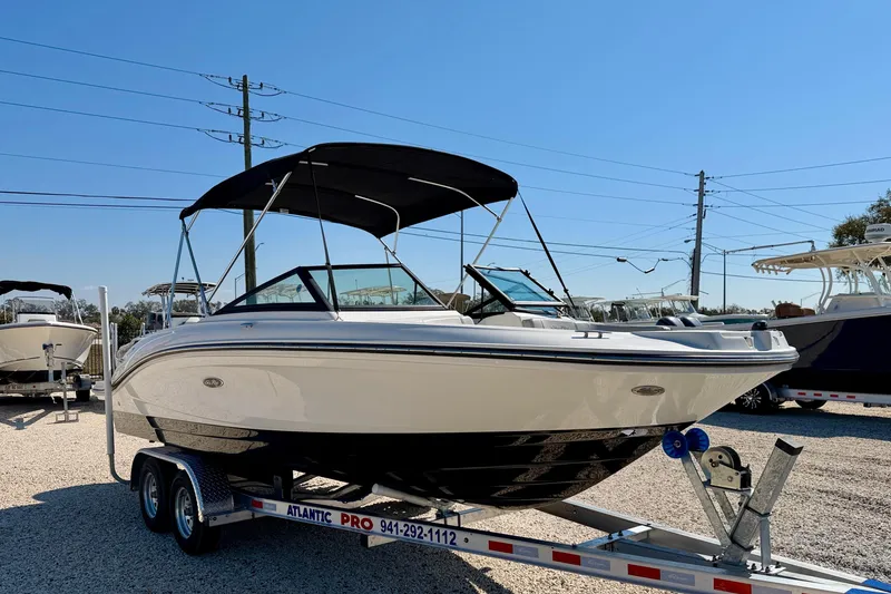 Slide: The Image of 2023 Sea Ray SPX 210 Outboard boat on trailer under clear blue sky. - 3