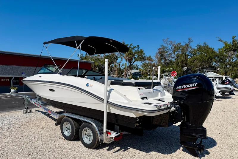 Slide: The Image of 2023 Sea Ray SPX 210 Outboard boat with Mercury engine on trailer, parked outdoors. - 7