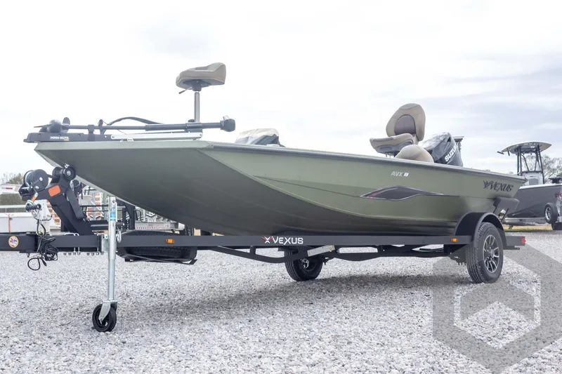 Slide: The Image of 2026 Vexus Defender 181 boat on trailer, green exterior, parked on gravel. - 11