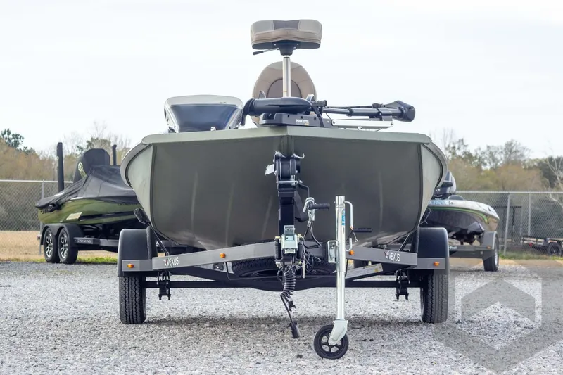 Slide: The Image of 2026 Vexus Defender 181 boat on trailer, parked on gravel lot. - 2