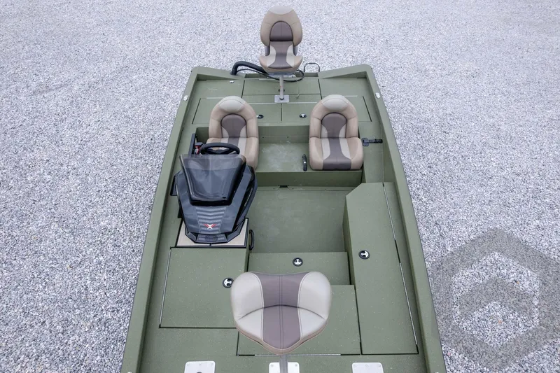 Slide: The Image of 2026 Vexus Defender 181 boat with green deck and beige seats, parked on gravel. - 62