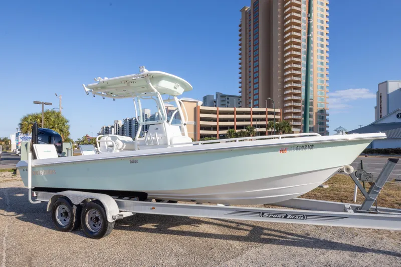 The Image of 2008 Everglades 243 Center Console boat on trailer, urban backdrop, clear sky. - 1