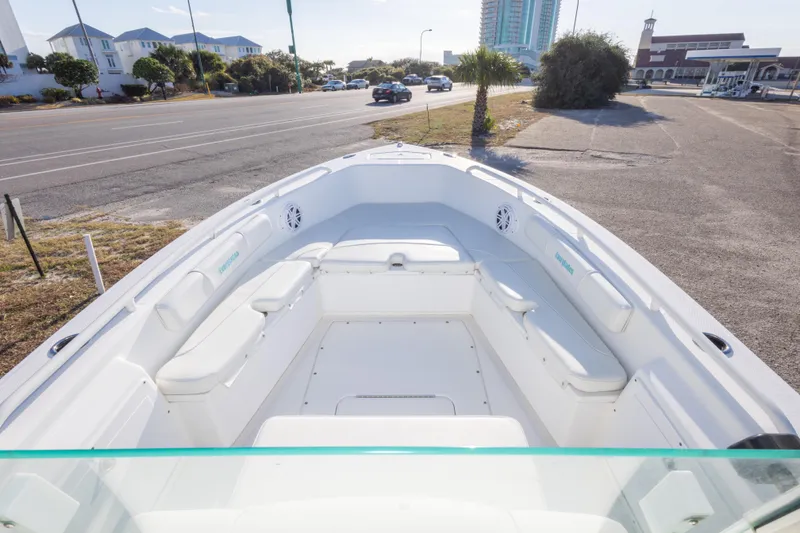 Slide: The Image of 2008 Everglades 243 Center Console boat with spacious seating, parked near a coastal road. - 17