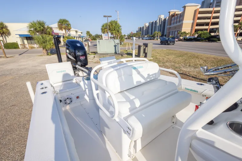 Slide: The Image of 2008 Everglades 243 Center Console boat with seating and outboard motor, parked near buildings. - 21