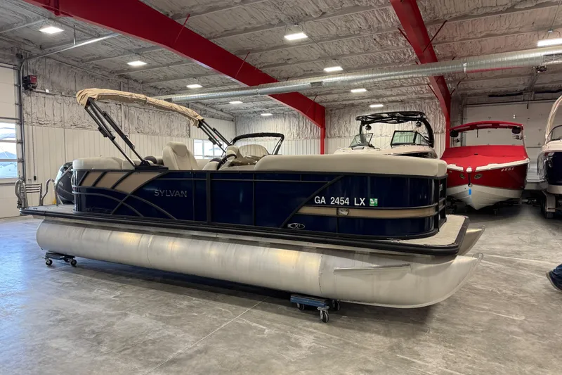 The Image of 2023 Sylvan X-3 pontoon boat in a showroom, featuring a sleek design and modern amenities. - 1