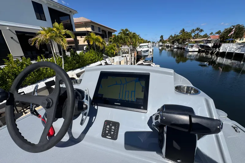 Slide: The Image of Helm of 2026 Costa Custom Boats 264 HC with navigation display, docked in a scenic canal. - 13