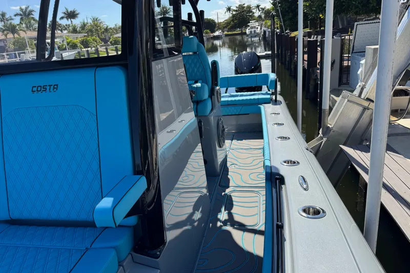 Slide: The Image of 2026 Costa Custom Boats 264 HC interior with blue seating and sleek design. - 19