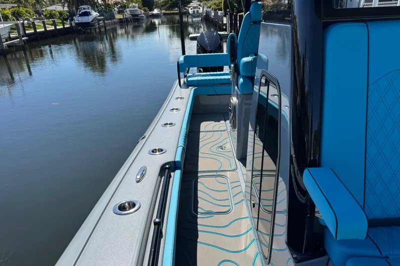 Slide: The Image of 2026 Costa Custom Boats 264 HC, sleek design, blue interior, docked on calm water. - 20