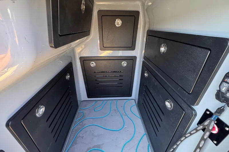 Slide: The Image of Storage compartments inside 2026 Costa Custom Boats 264 HC, featuring sleek black panels and modern design. - 22