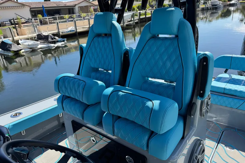 Slide: The Image of Luxurious blue seating on 2026 Costa Custom Boats 264 HC, docked by waterfront homes. - 28