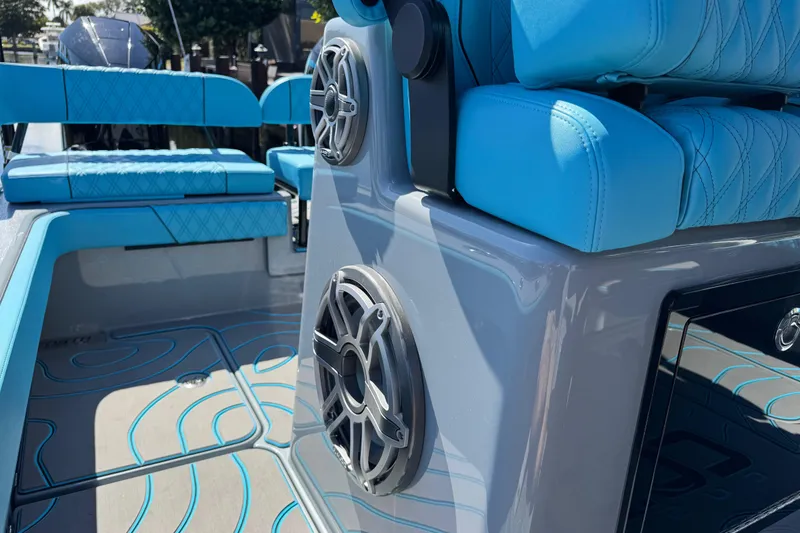 Slide: The Image of 2026 Costa Custom Boats 264 HC interior with blue seating and marine speakers. - 33