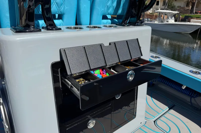 Slide: The Image of 2026 Costa Custom Boats 264 HC with open tackle storage, featuring blue seating and cup holders. - 48